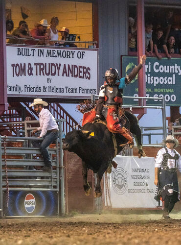 Bull rider under the National Veterans Rodeo banner