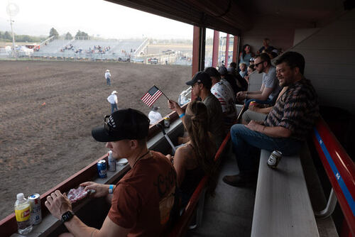 Spectators watching the rodeo from the shade