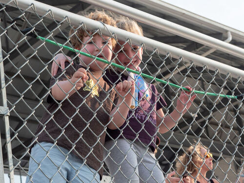 Kids watching the action from the arena fence